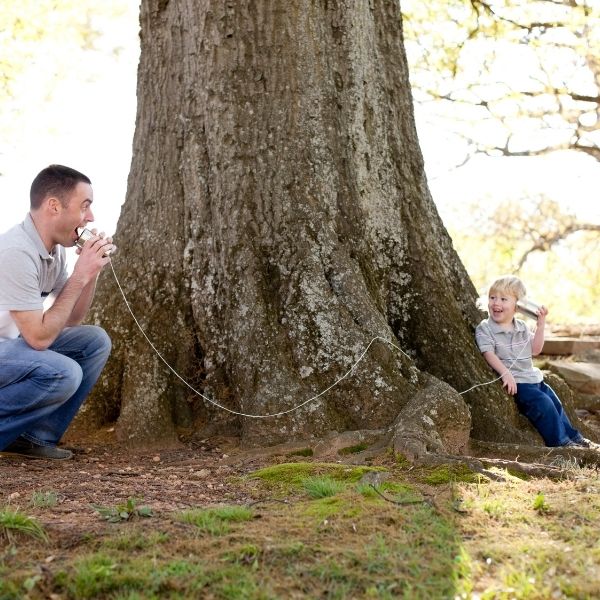 An image of a dad playing the telephone game with his son