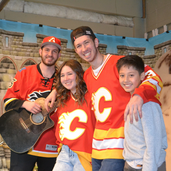 Image of a group of kids smiling wearing a Flames jersey